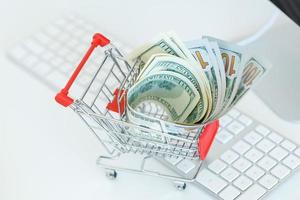 Dollars in the shopping cart on a computer keyboard photo