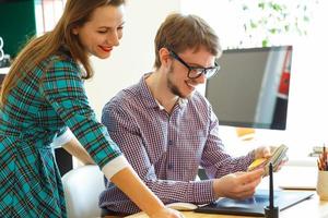 Man and woman looking to a color paint palette at home office photo