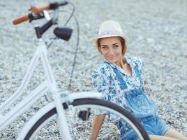 Happy woman with bicycle on the beach photo