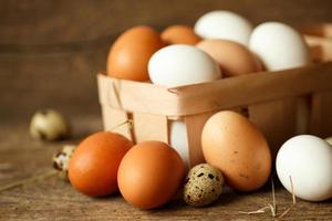 Chicken and quail eggs on a wooden rustic background photo