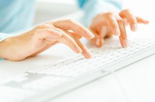 Woman office worker typing on the keyboard photo