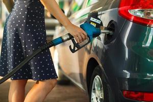 mujer llena gasolina dentro su coche foto