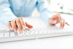 Woman office worker typing on the keyboard photo