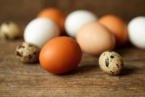 Chicken and quail eggs on a wooden rustic background photo