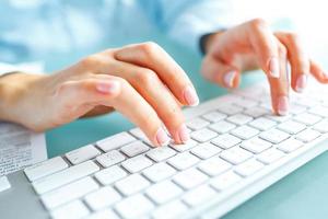 Woman office worker typing on the keyboard photo