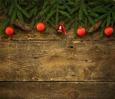 Christmas tree branches with cones and christmas decorations on wooden texture ready for your design photo