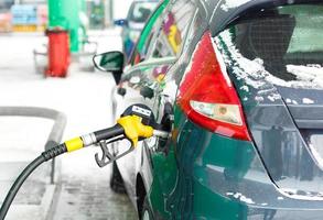 coche repostaje en un gasolina estación en invierno foto