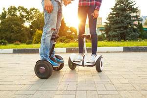 Young couple riding hoverboard - electrical scooter, personal eco transport, gyro scooter, smart balance wheel photo