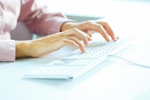 Woman office worker typing on the keyboard photo