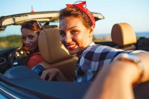 dos joven muchachas conducción un cabriolé foto