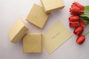 Top view of gift box and rose flower on color background photo