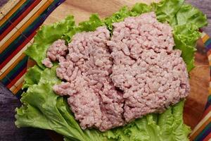 Cerca de carne picada en una tabla de cortar en la mesa foto