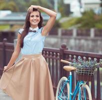 joven mujer hermosa, elegantemente vestida con bicicleta foto