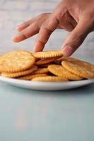 close up of hand pick sweet cookies on wooden table photo