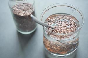 Cerca de semillas de chía en un vaso de agua. foto