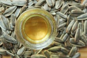 sunflower oil seed and oil in a container on table photo