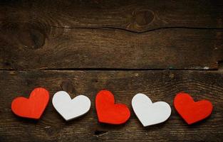 Red and white hearts on old wooden background photo