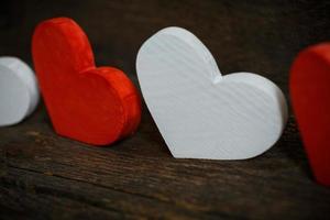 Red and white hearts on old shabby wooden background photo