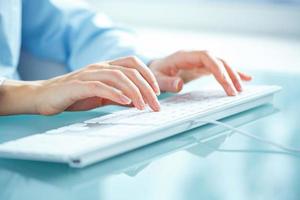 Woman office worker typing on the keyboard photo