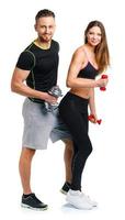 Sport couple - man and woman with dumbbells on the white photo