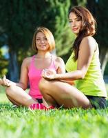 dos linda joven muchachas relajante al aire libre foto