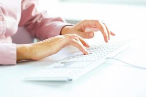 Woman office worker typing on the keyboard photo