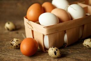 Chicken and quail eggs on a wooden rustic background photo