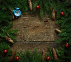 Christmas tree branches with cones and christmas decorations on wooden texture ready for your design photo