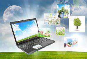 Laptop against green nature background photo