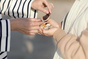 Closeup of child girl's hands giving many seashells to her young mother with love and tenderness. child and parents on a trip, the ocean seashore, hands of mother and daughter. High quality photo