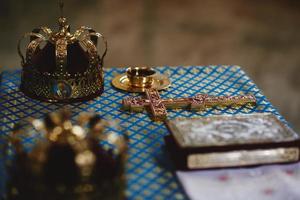 Orthodox golden wedding crowns, church icons, church books, gospel on the table. selective focus photo