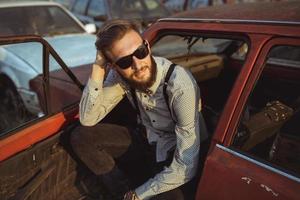 joven hermoso elegante hombre, vistiendo camisa y corbata de moño con antiguo carros foto