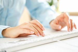 Woman office worker typing on the keyboard photo