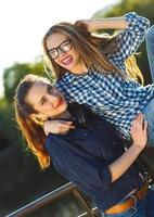 Two playful young women having fun outdoors photo