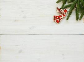 Christmas tree branches with christmas decorations on white wooden texture ready for your design photo