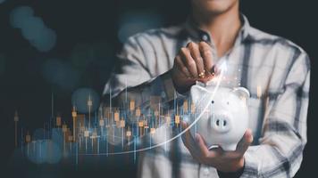 investor put coin money in piggy bank ,Financial interest rates ,investment growth percentage and interest on deposits ,an increase in interest rates ,stock market ,Dividends , Retirement returns photo