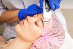 joven mujer recepción facial ultrasónico limpieza foto