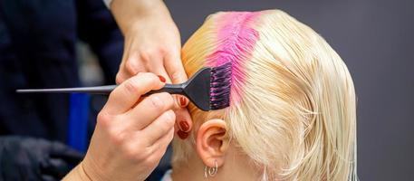 Hairdresser dyeing hair in pink photo