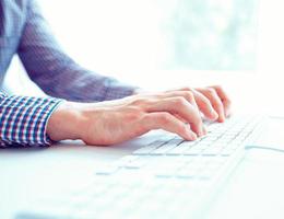 Male hands or men office worker typing on the keyboard photo