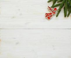 Christmas tree branches with christmas decorations on white wooden texture ready for your design photo