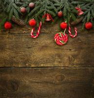 Christmas border with fir tree branches, cones, christmas decorations and candy canes photo