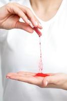 Manicurist pours red pigment nail powder photo