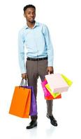 Happy african american man holding shopping bags on white background photo