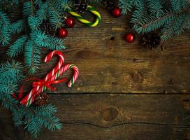 Christmas border with fir tree branches, cones, christmas decorations and candy cane photo