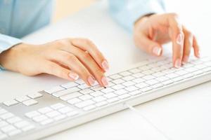 Woman office worker typing on the keyboard photo