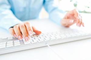 Woman office worker typing on the keyboard photo