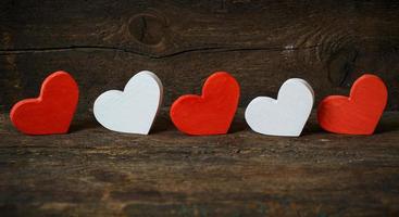 Red and white hearts on old wooden background photo