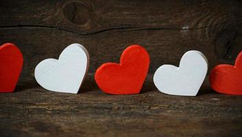 Red and white hearts on old wooden background photo