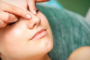 Young woman getting facial massage photo