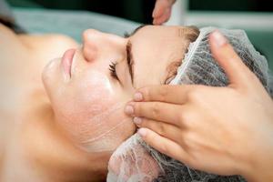 Young woman getting facial massage photo